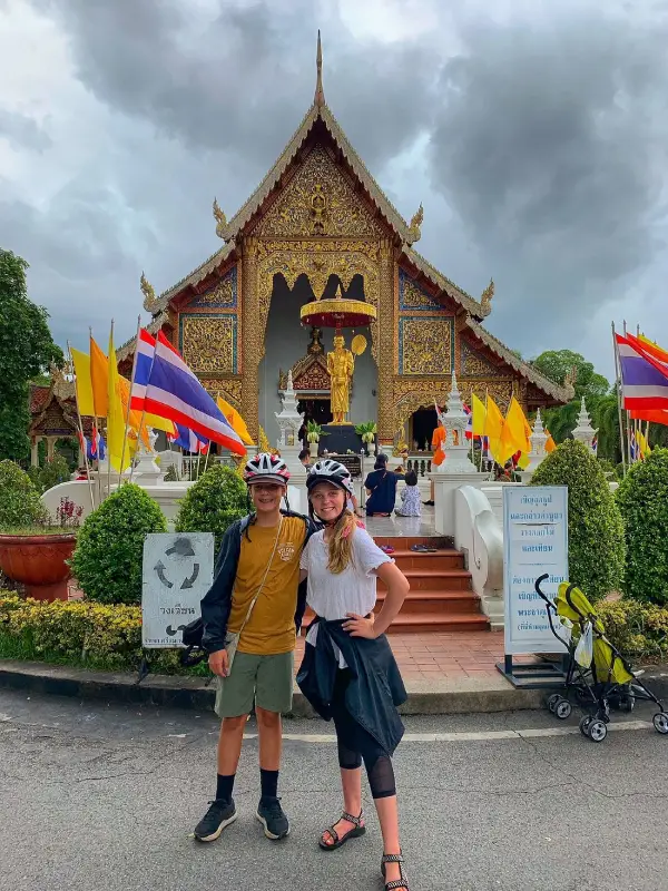 Visitantes capturam fotos animadas e cheias de energia em frente ao Ubosot