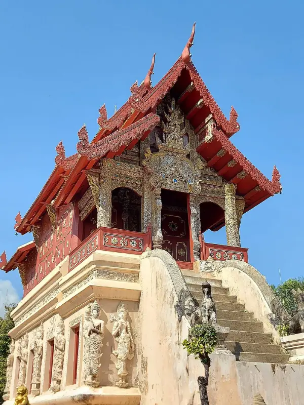 De perto, o Ho Trai impressiona com seu telhado vermelho e entalhes ricamente decorados
