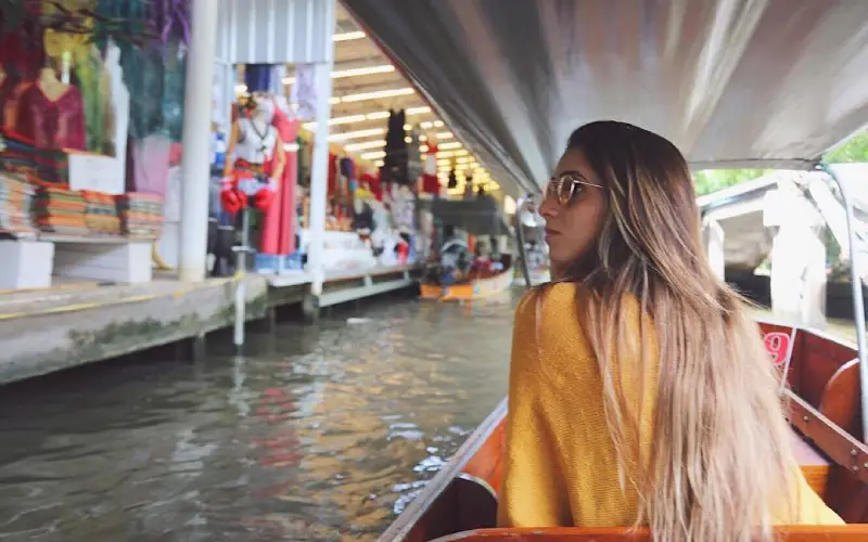 Visitantes aproveitam o passeio de barco observando a vida local dos dois lados do canal
