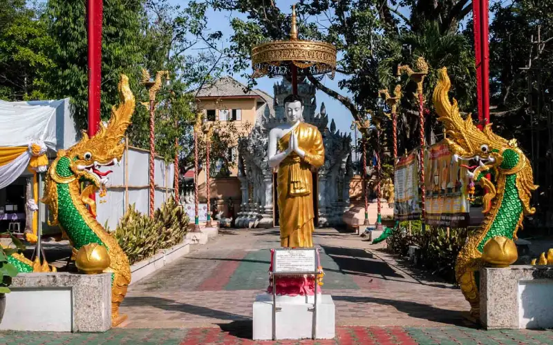 Visitantes admiram entalhes, stupas douradas e relíquias