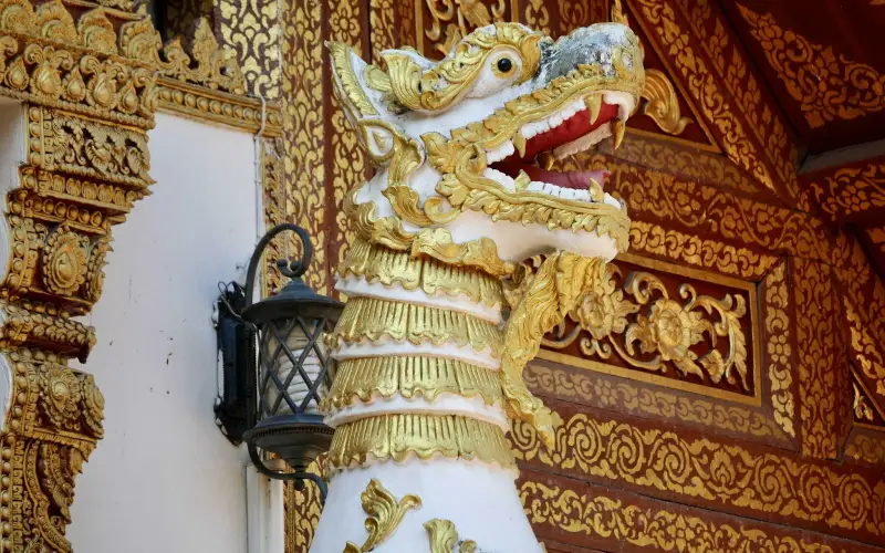 Estátua ornada em Wat Phra Singh exibe arte Lanna