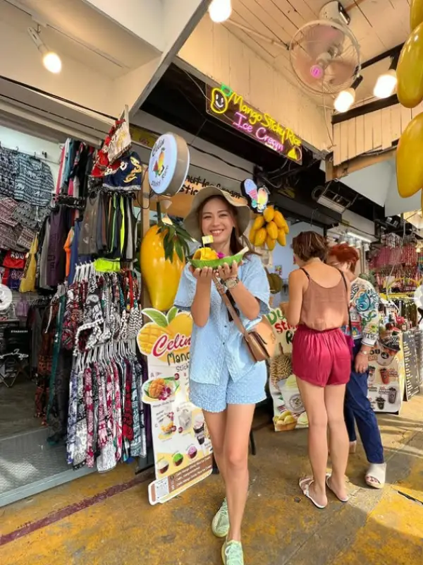 Visitante saboreia manga com arroz no mercado