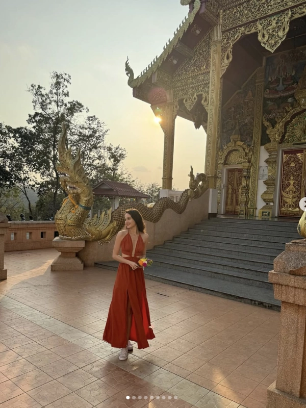 Visitante diante de templo com dragões dourados