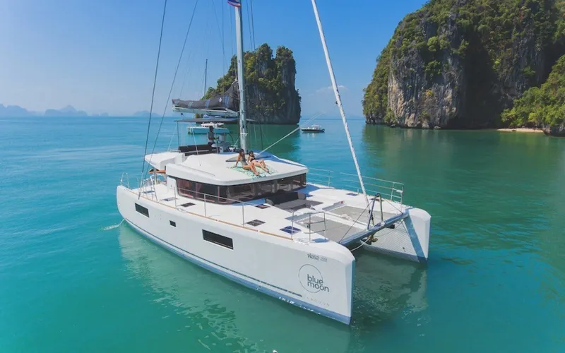 Catamarã cruza águas calmas em Phuket com paisagem