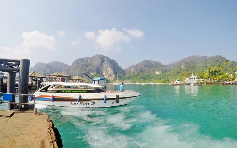 Lanchas cortam ondas turquesa rumo a Koh Phi Phi
