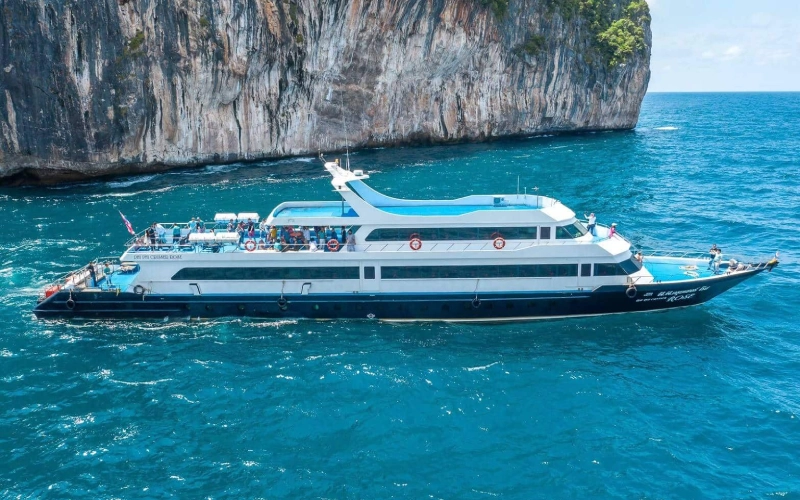 Viajantes navegam por águas cênicas de ferry a caminho da vibrante Koh Phi Phi