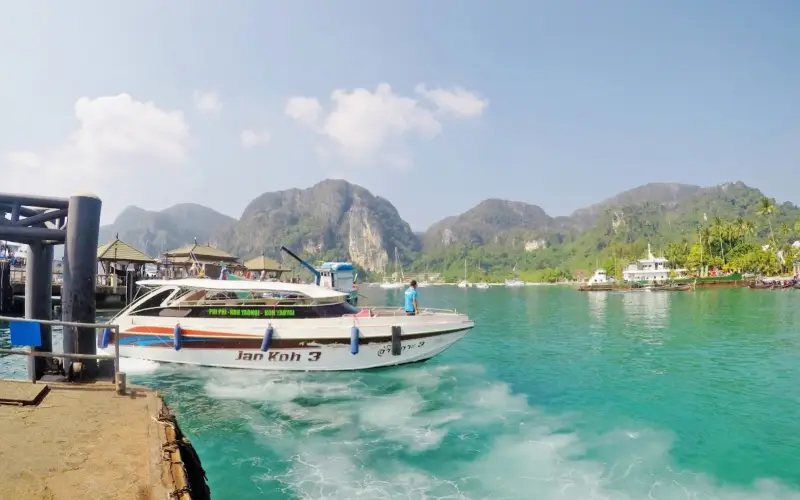 Lanchas cortam ondas turquesa rumo a Koh Phi Phi