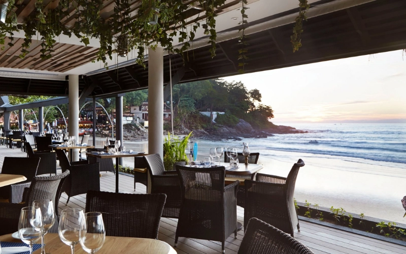 O Boathouse Phuket é um restaurante premiado à beira-mar que serve pratos tailandeses, franceses e frutos do mar, com música ao vivo