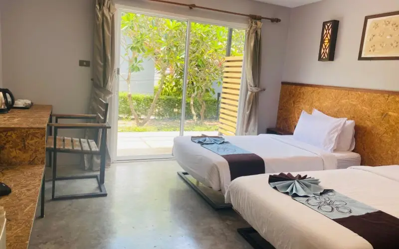 Os quartos do hotel oferecem vistas para o jardim através de amplas e arejadas janelas de vidro