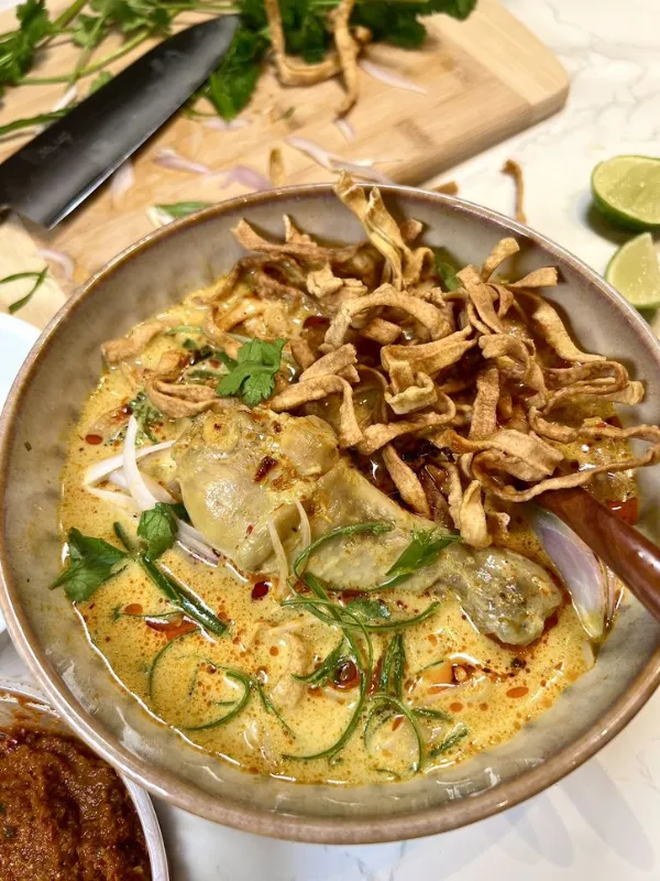 Tailandeses cozinham Khao Soi com macarrão e curry