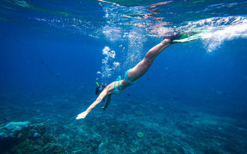 Visitante mergulha com snorkel nas águas cristalinas