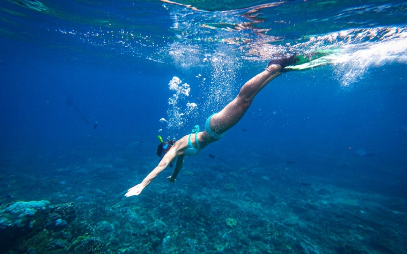 Visitante mergulha com snorkel nas águas cristalinas