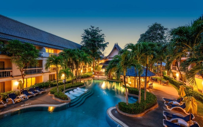 Resort com piscinas, palmeiras e crianças brincando