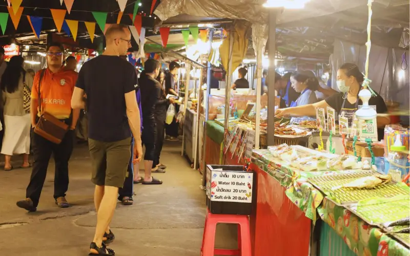 Viajantes curtem barracas no mercado noturno Krabi