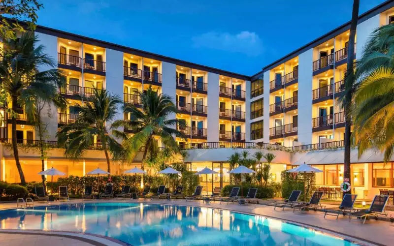 Foto street view do Ibis Phuket Patong com palmeiras.