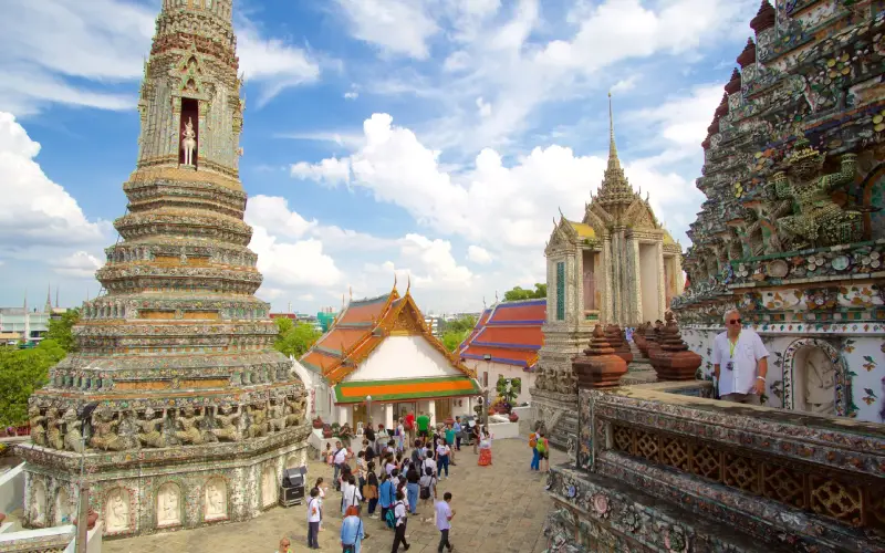Viajantes sobem o icônico prang do Wat Arun