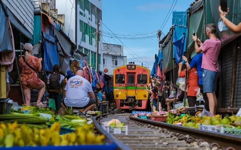 Visitantes fotografam trem passando perto das barracas