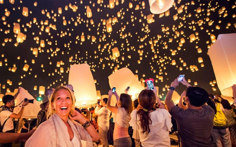 Participar do festival com lanternas iluminando o céu noturno
