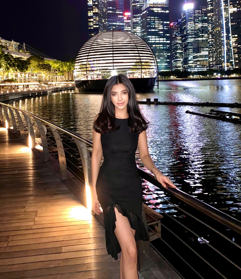 As luzes coloridas das árvores artificiais brilham sob o céu noturno moderno de Singapura