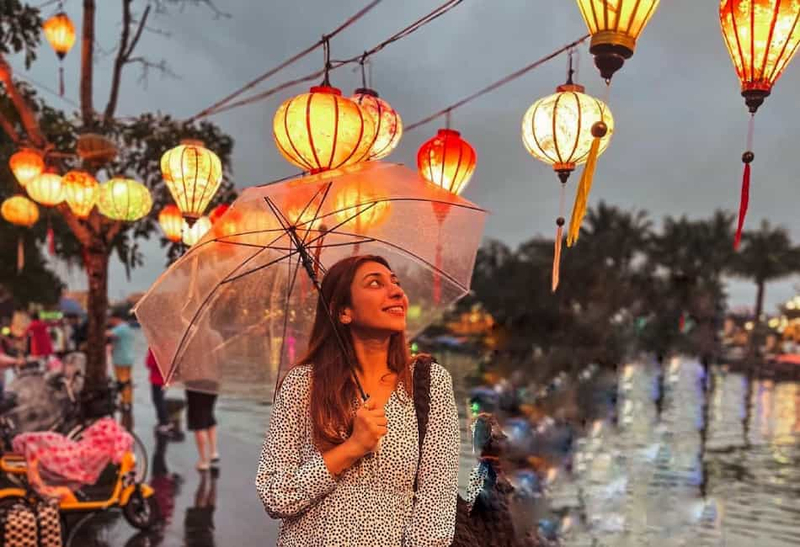 Lanternas coloridas de seda iluminam as margens do rio na cidade histórica de Hoi An durante o entardecer