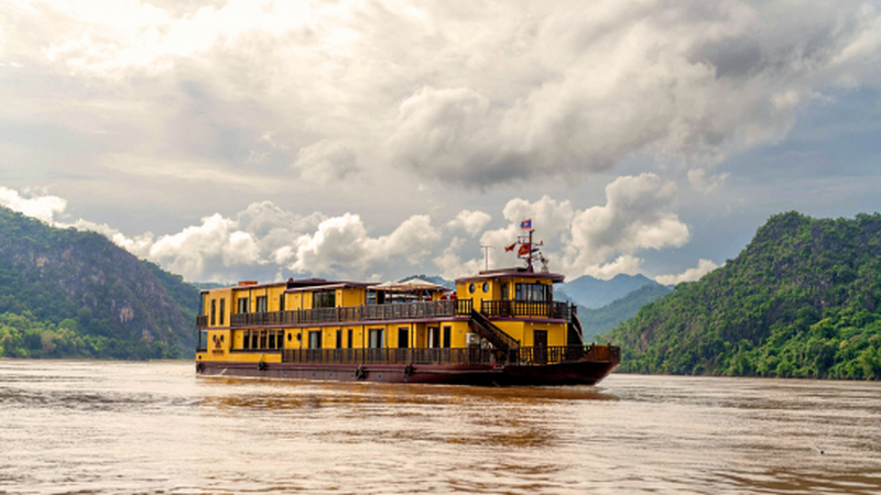 O barco navega suavemente pelo Rio Mekong