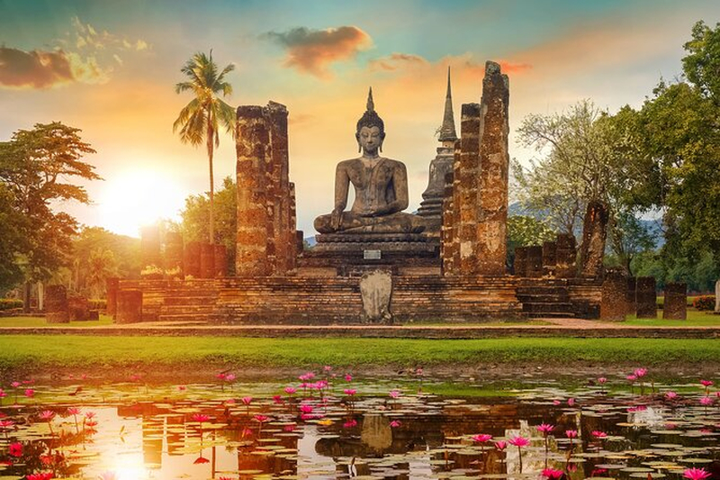 O pôr do sol alaranjado emoldura as ruínas de pedra e estupas ancestrais da cidade histórica de Ayutthaya