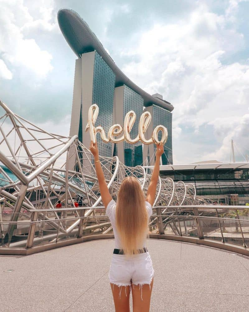 O visitantes observa a linha do horizonte moderna de Singapura ao entardecer com o imponente Marina Bay Sands
